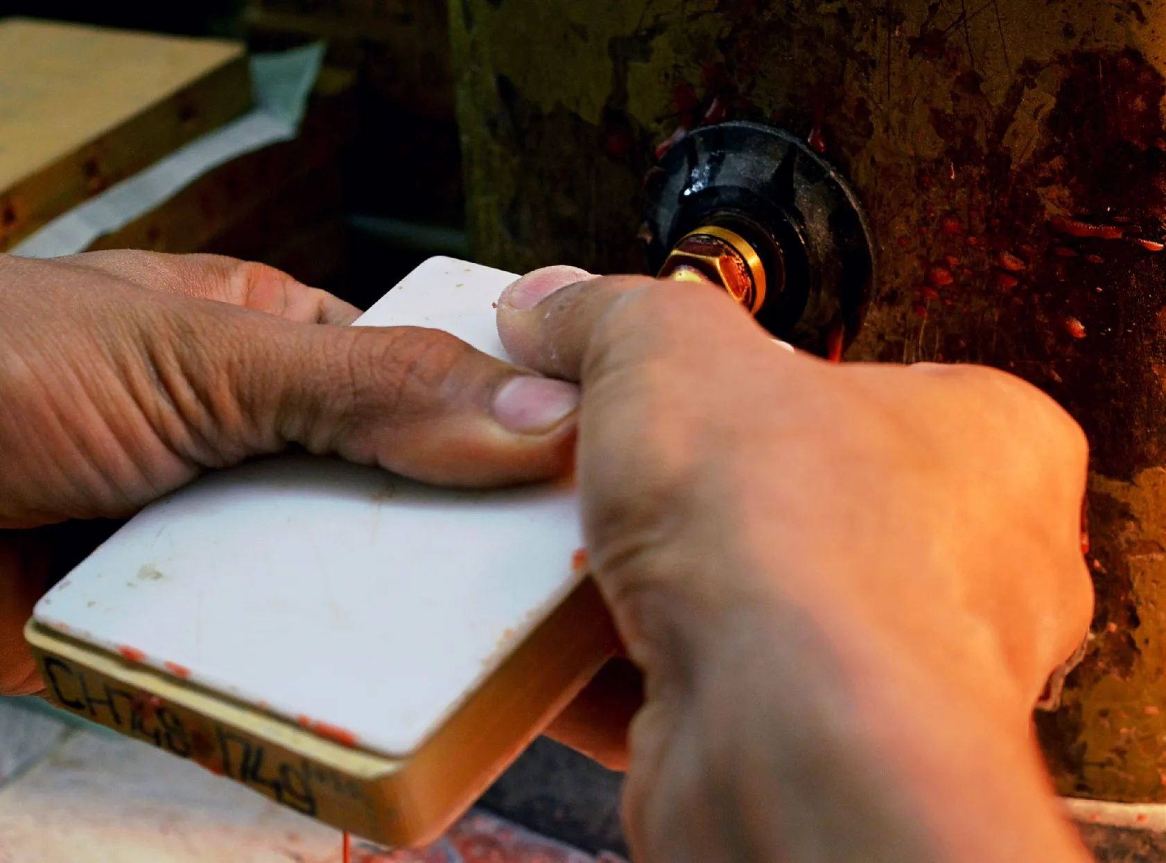 Hands shaping a wax model with a heated tool
