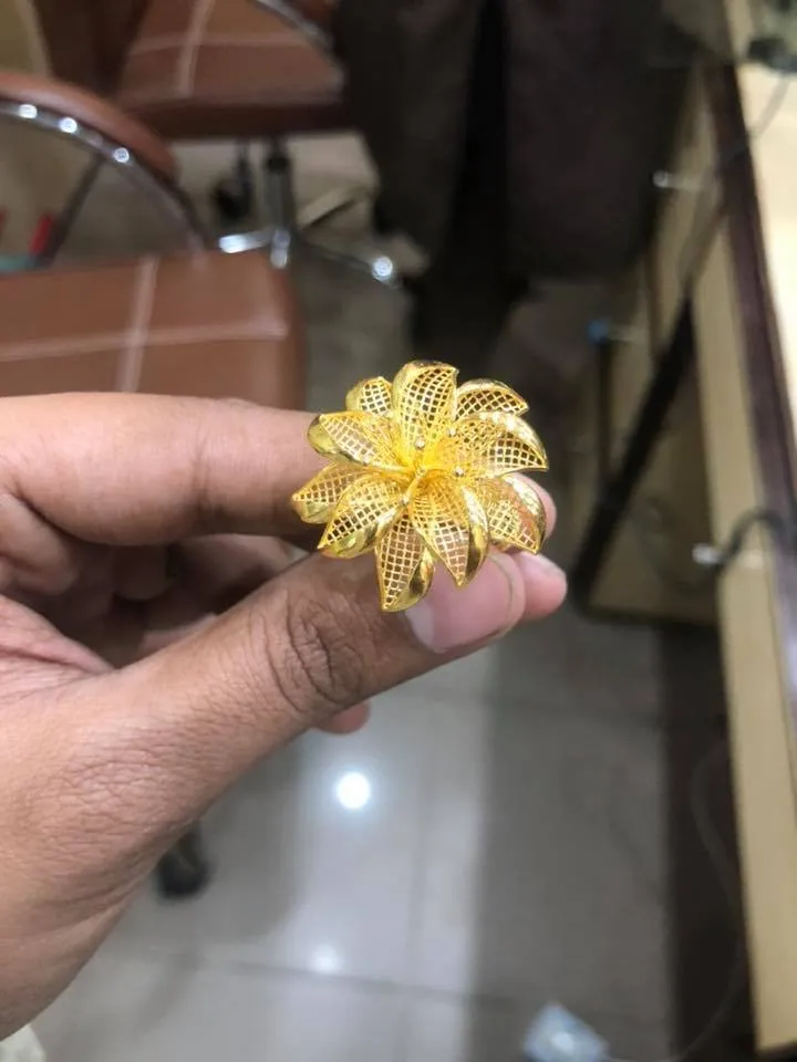 A resin jewelry model, printed in the workshop, held between two fingers