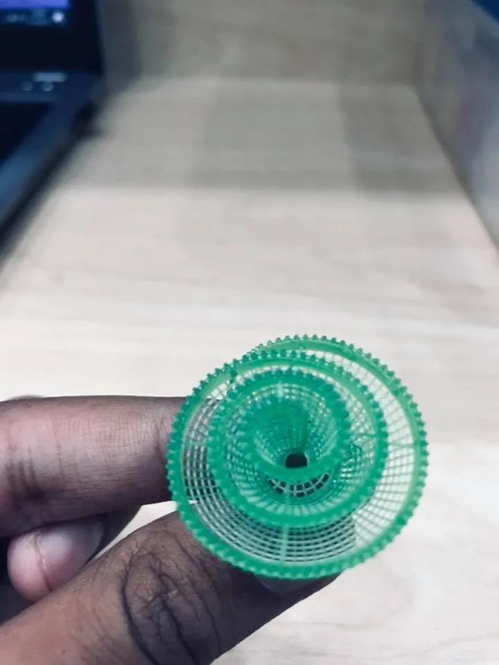 A resin jewelry model, printed in the workshop, held between two fingers