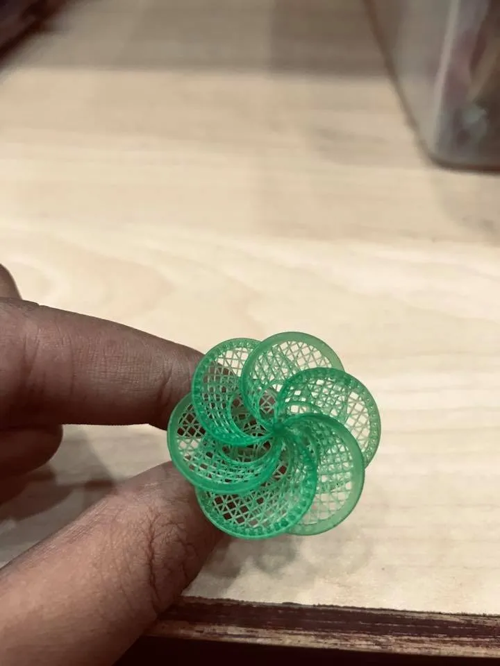 A resin jewelry model, printed in the workshop, held between two fingers