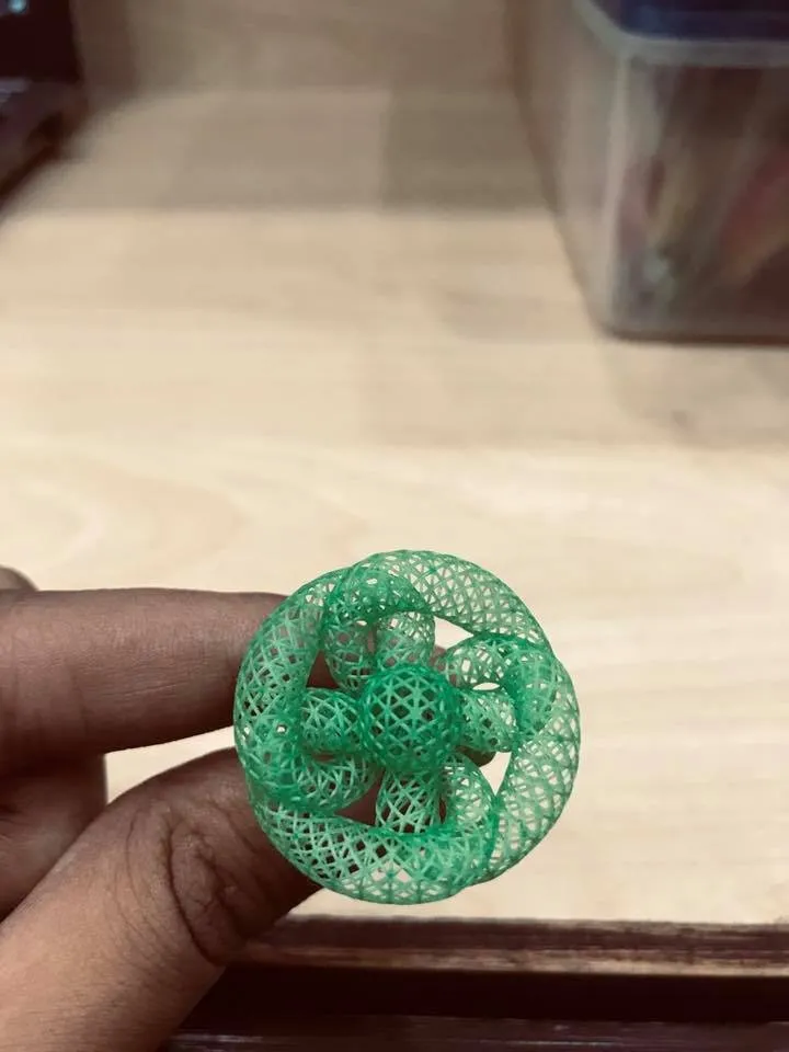 A resin jewelry model, printed in the workshop, held between two fingers