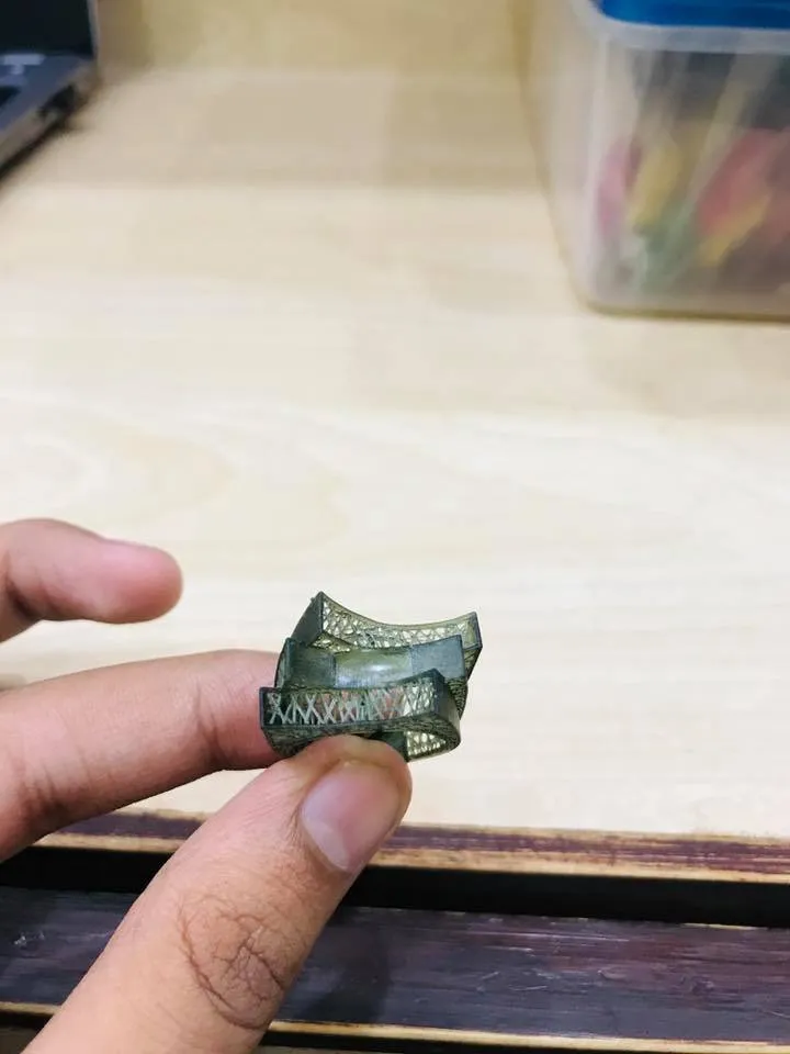 A resin jewelry model, printed in the workshop, held between two fingers