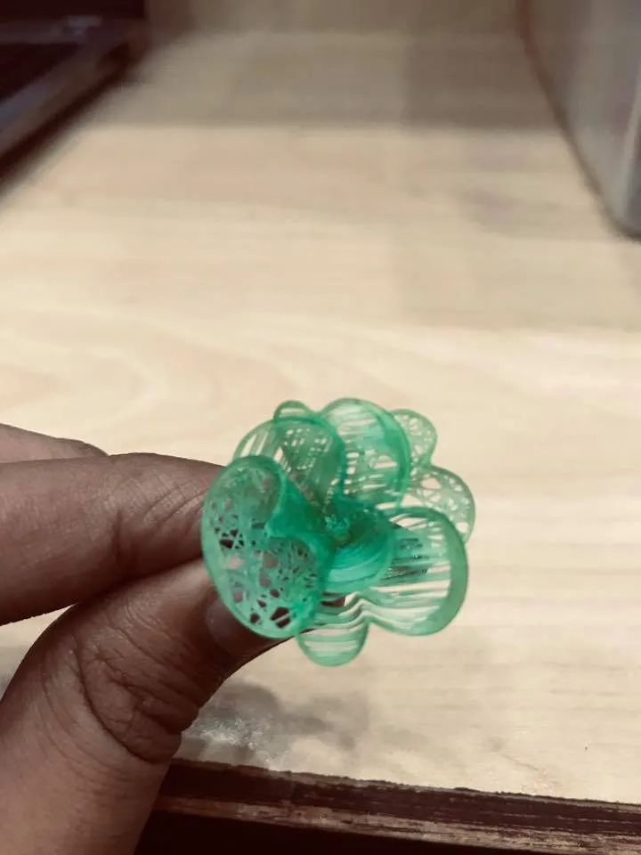 A resin jewelry model, printed in the workshop, held between two fingers