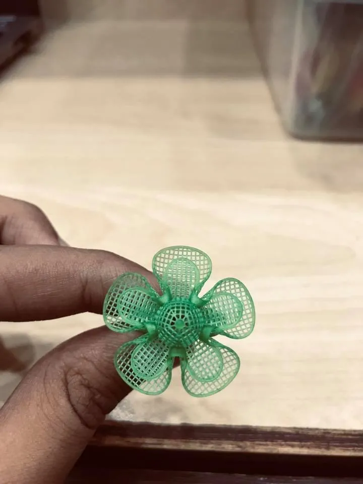 A resin jewelry model, printed in the workshop, held between two fingers