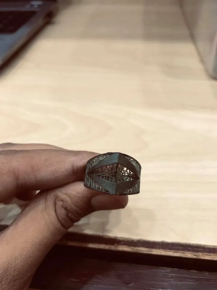 A resin jewelry model, printed in the workshop, held between two fingers